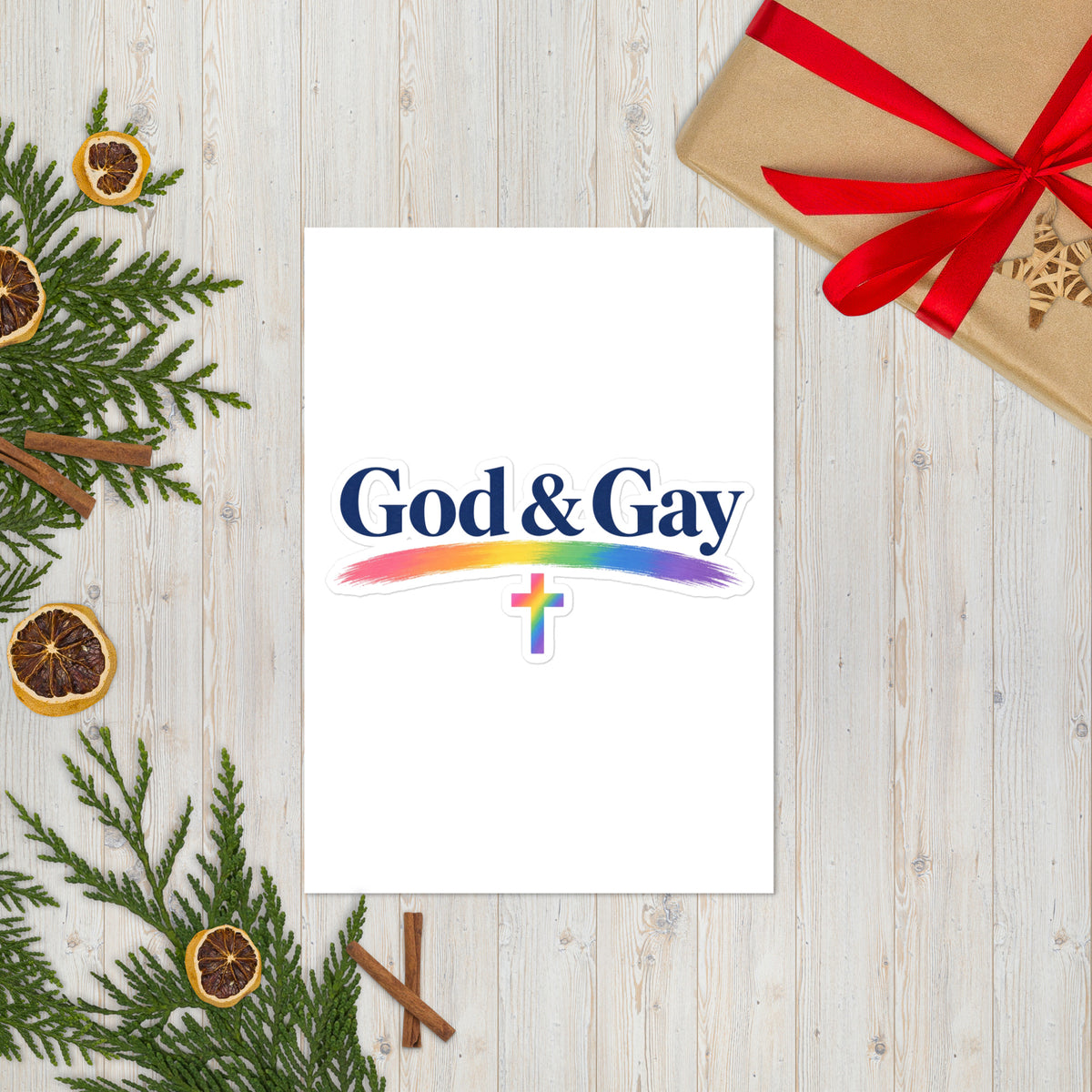 God & Gay sticker sheet on a wood surface, true scale